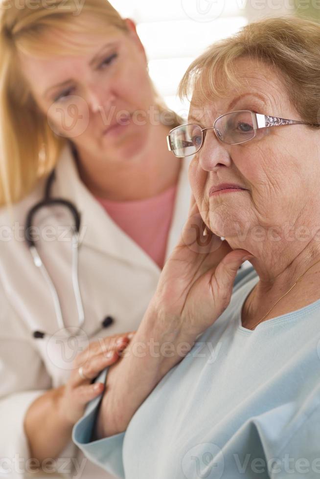 mujer adulta mayor siendo consolada por una doctora o enfermera foto