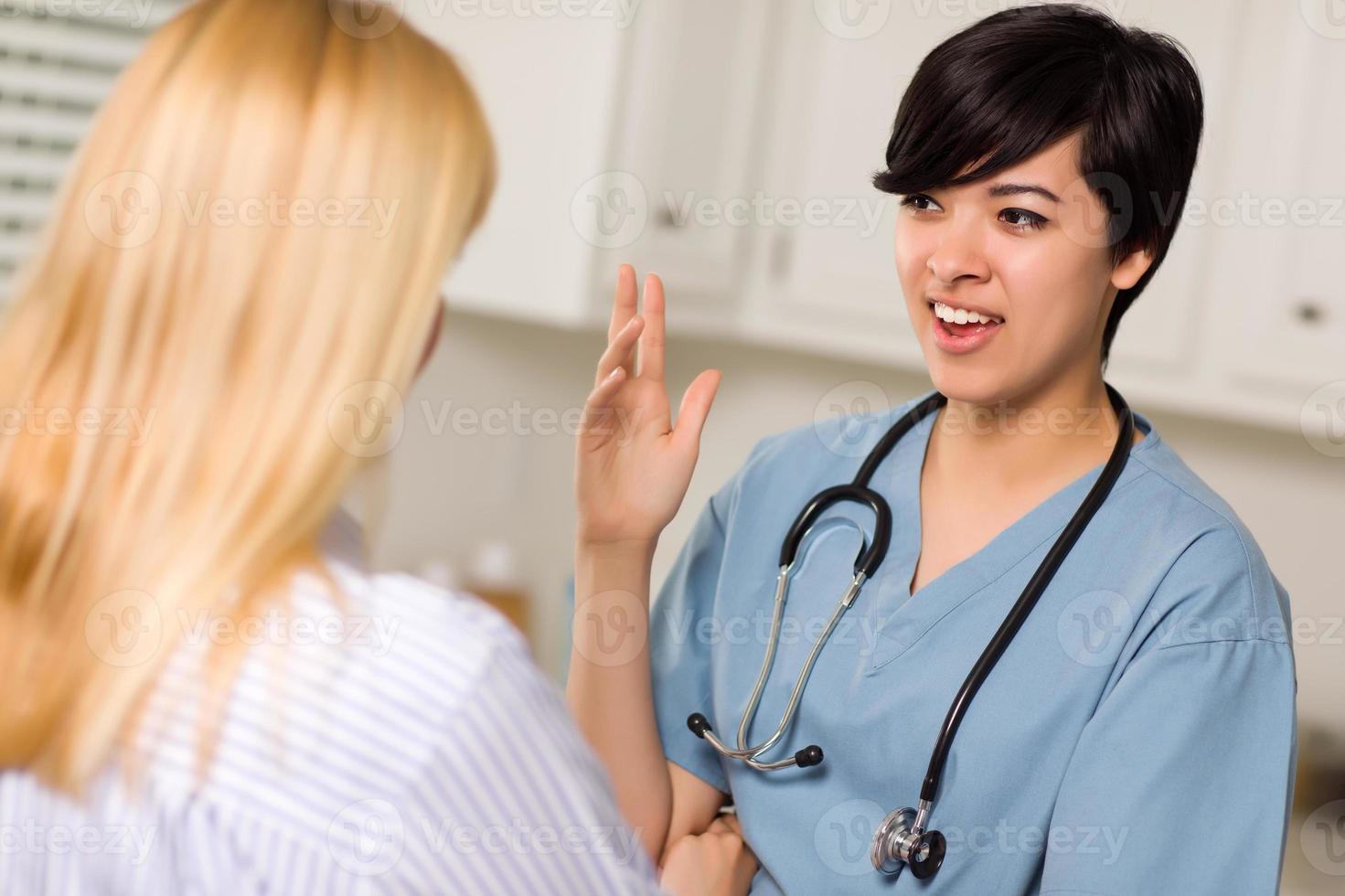 Attractive Mixed Race Young Female Doctor Talking with Patient photo