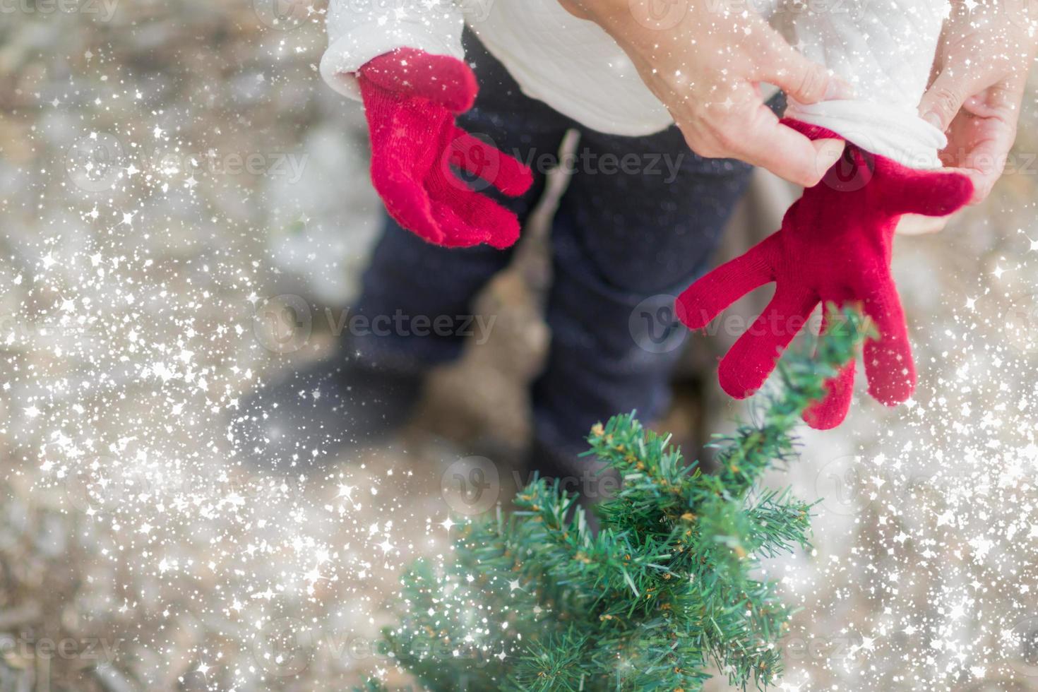 Mother Putting Red Mittens On Child with Snow Effect photo