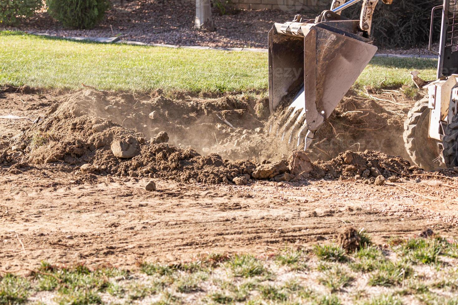 Small Bulldozer Digging In Yard For Pool Installation photo