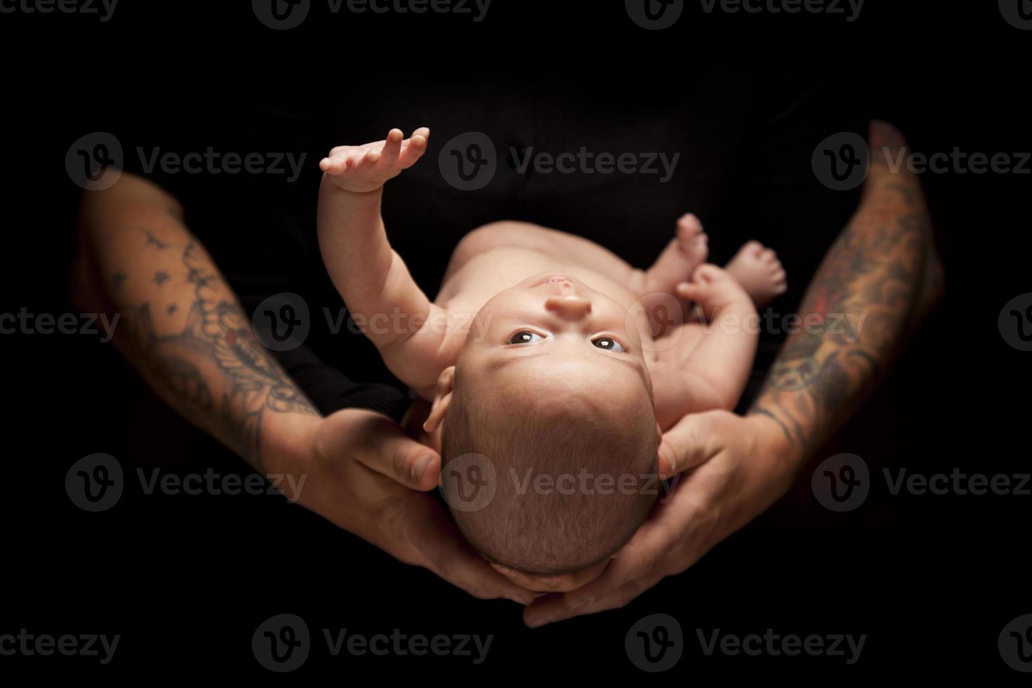 Hands of Father and Mother Hold Newborn Baby on Black photo