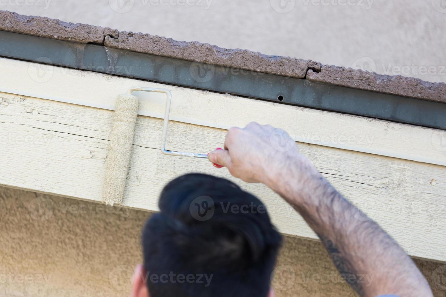 Professional Painter Using Small Roller to Paint House Fascia photo