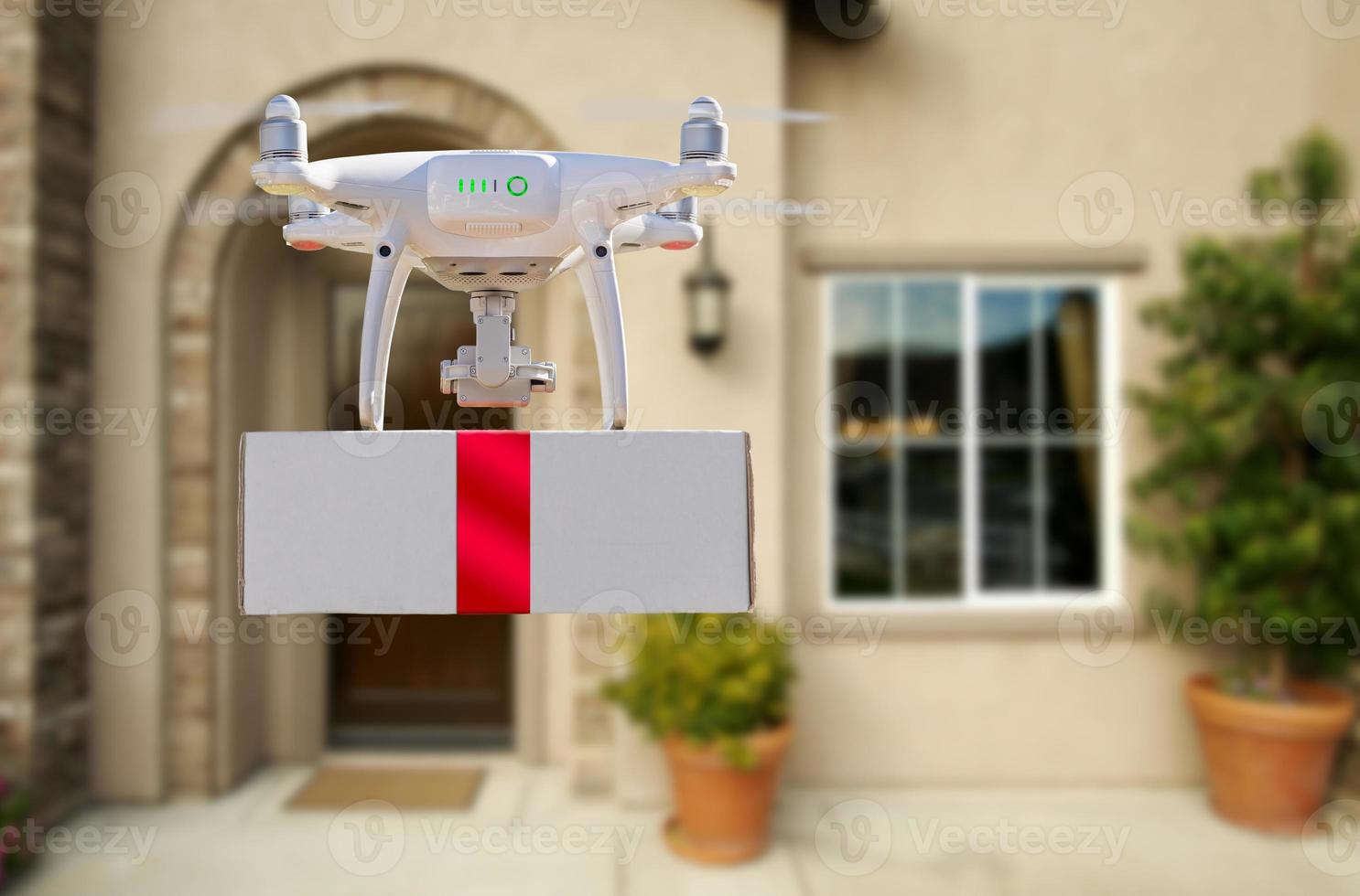 Unmanned Aircraft System UAV Quadcopter Drone Delivering Box With Red Ribbon To Home photo