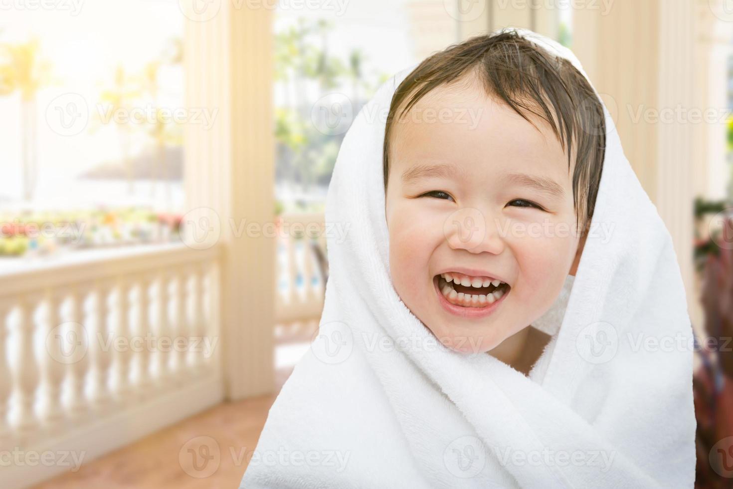 Happy Cute Mixed Race Chinese and Caucasian Boy On Tropical Patio Wrapped In A Towel photo