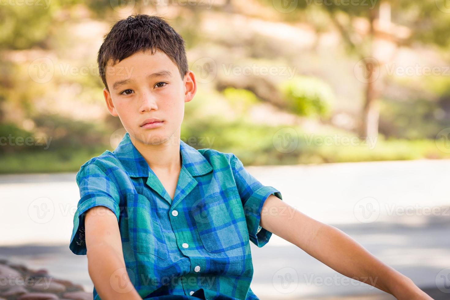 Outdoor portrait of a biracial Chinese and Caucasian boy. photo