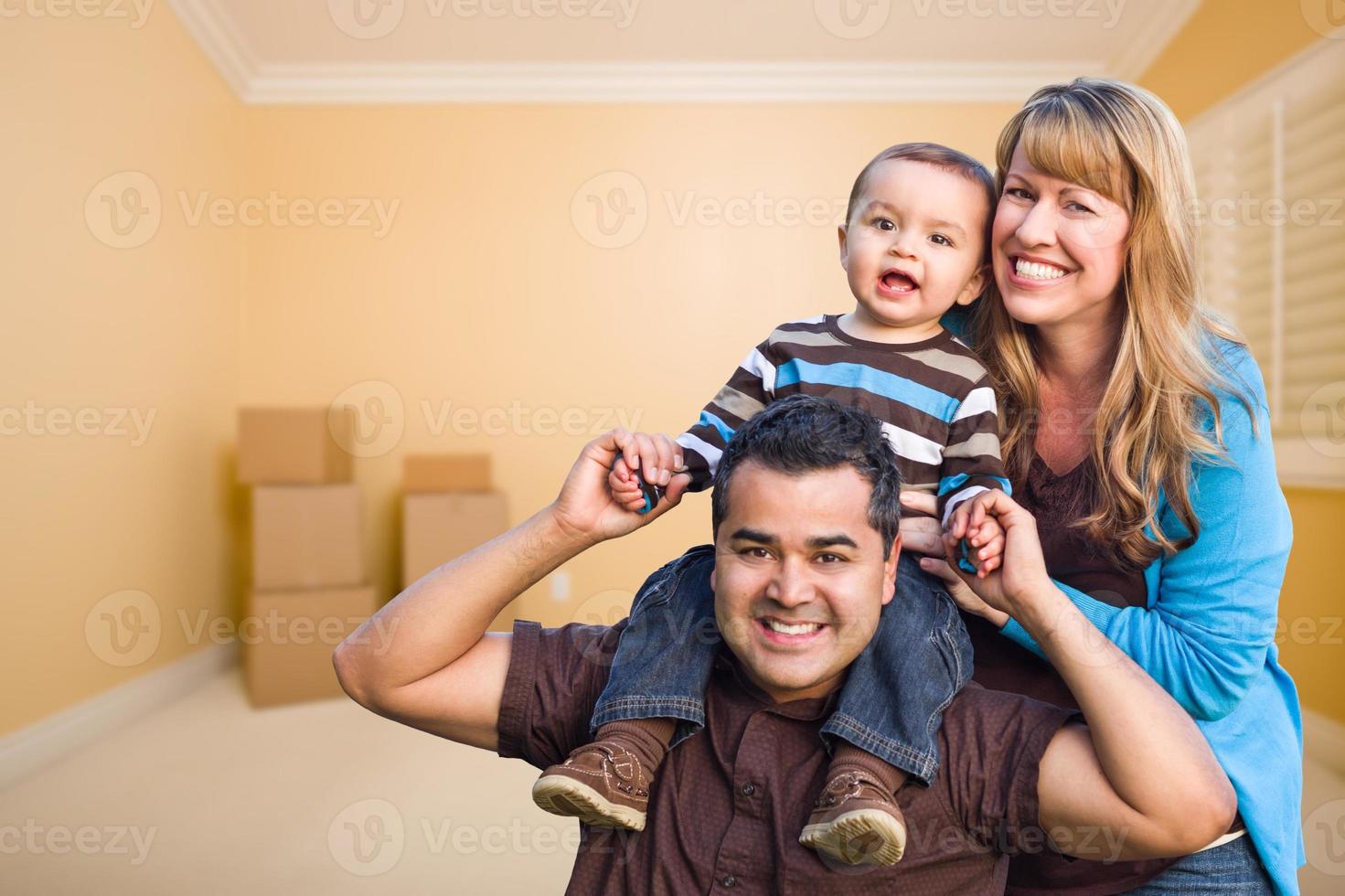 familia joven de raza mixta en la habitación con cajas móviles foto