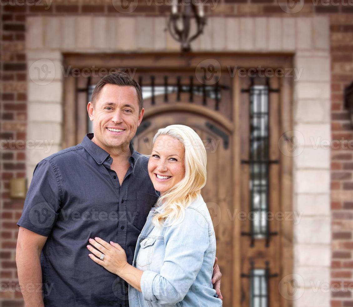 Happy Young Couple In Front of Front Door of New House photo