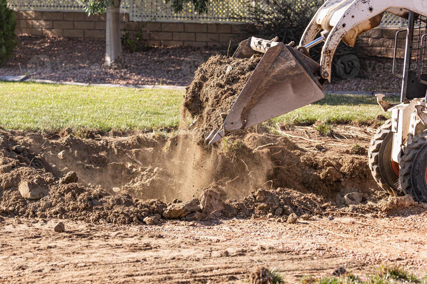 Small Bulldozer Digging In Yard For Pool Installation photo