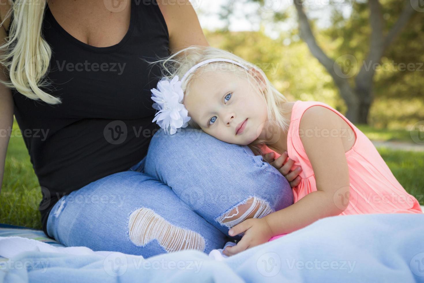 hermosa joven descansando en el regazo de su mamá en el parque foto