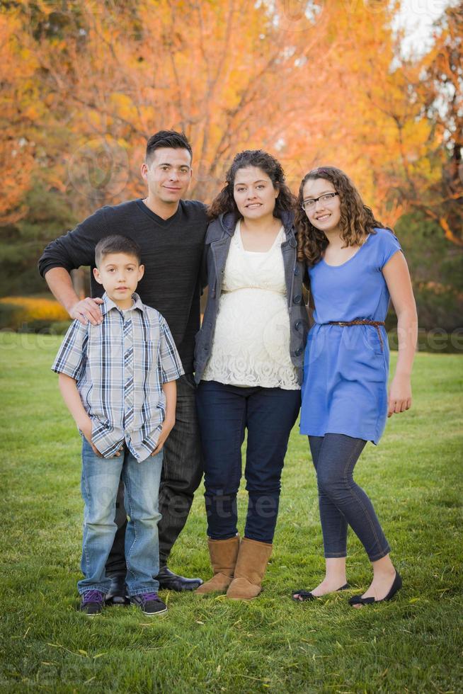 Attractive Hispanic Family Portrait in a Colorful Fall Outdoor Setting photo