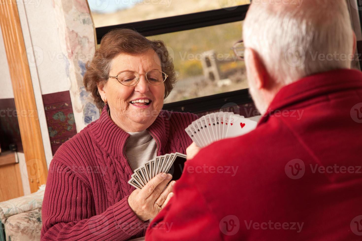 Happy Senior Adult Couple Playing Cards in Their Trailer RV photo