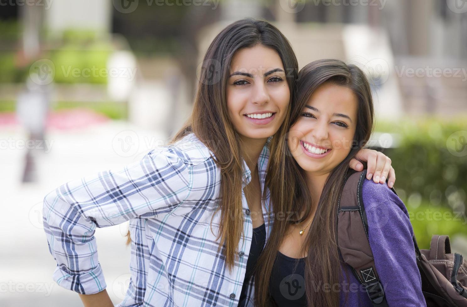 Mixed Race Female Students Carrying Backpacks on School Campus photo