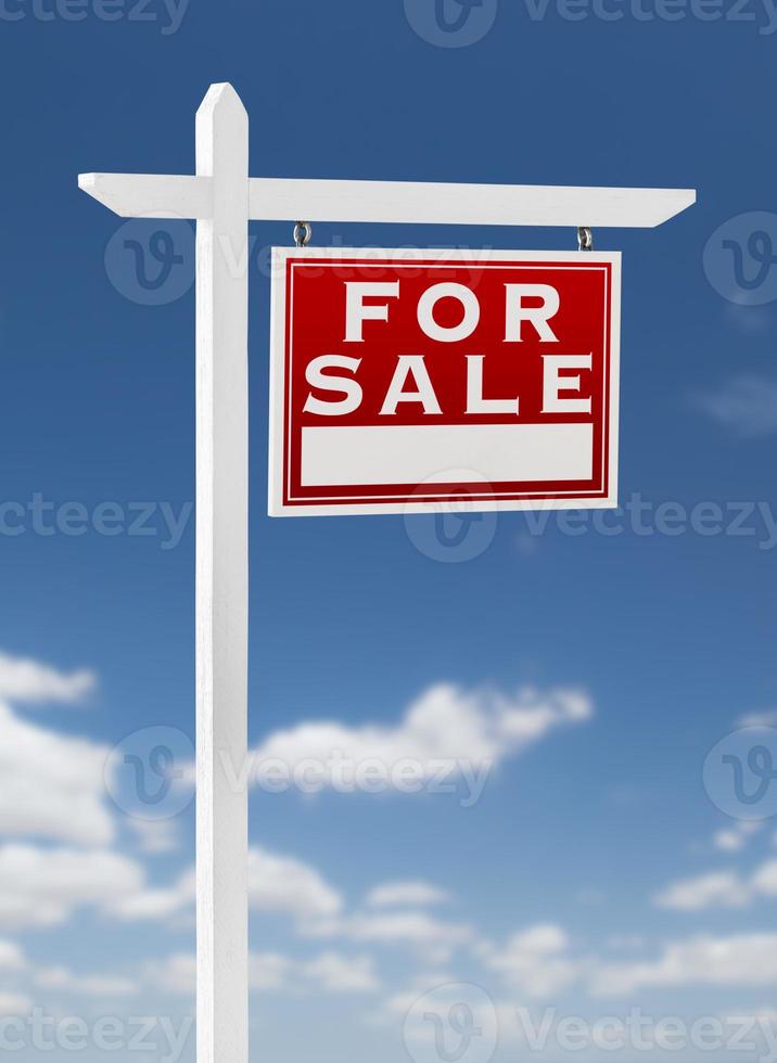 frente a la derecha en venta signo de bienes raíces en un cielo azul con nubes. foto