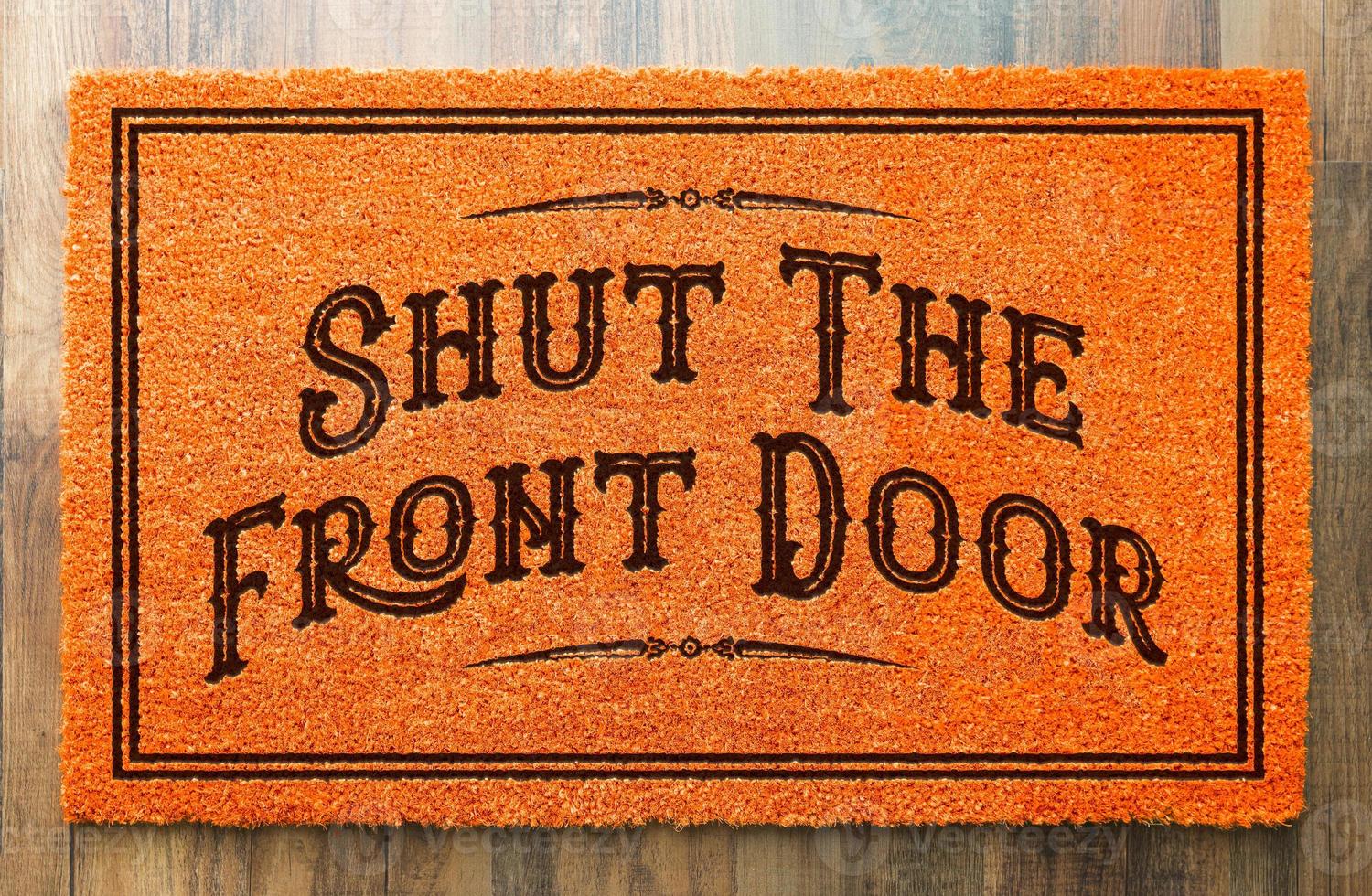 Shut The Front Door Halloween Orange Welcome Mat On Wood Floor Background photo