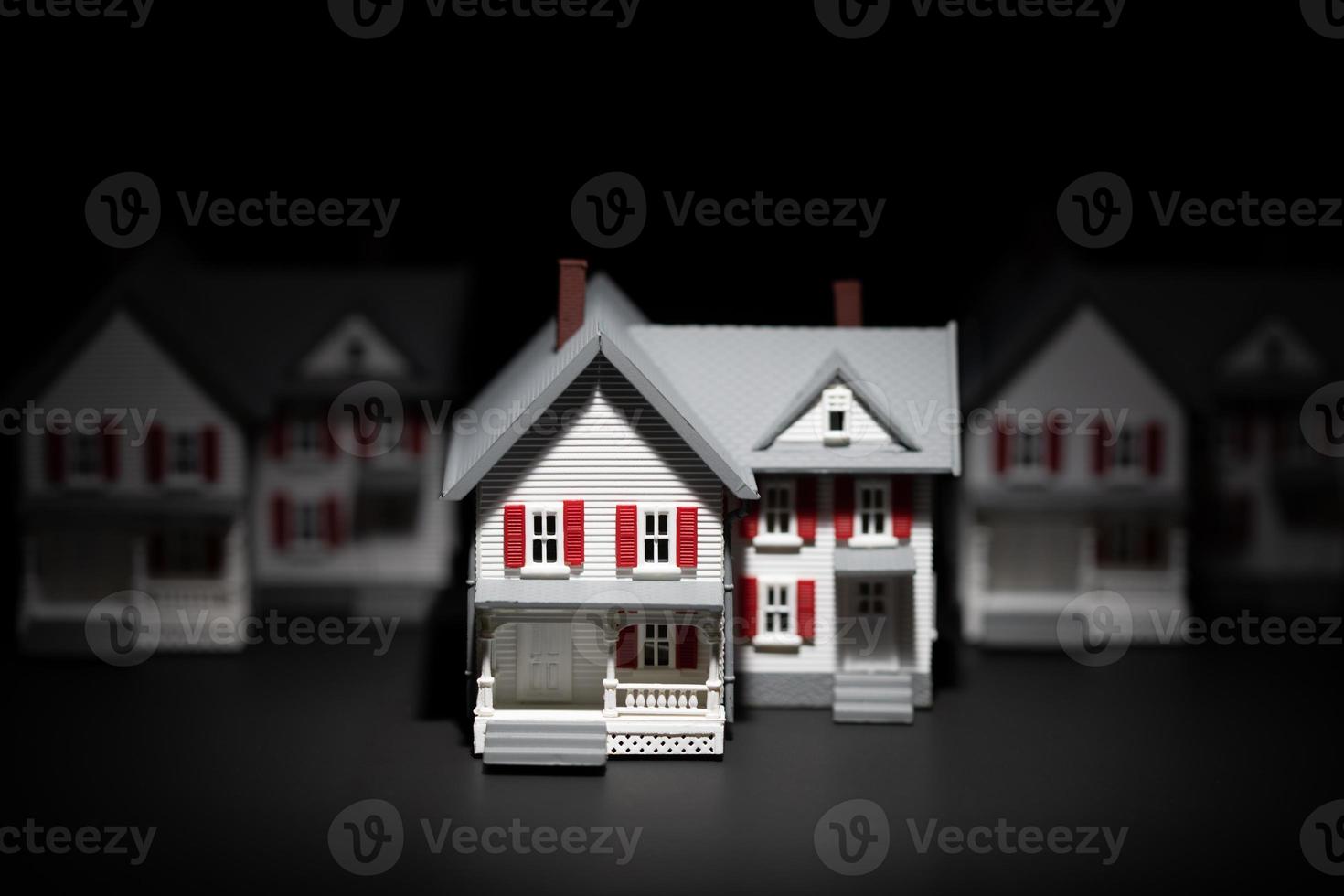 Several Model Houses In A Row With One Spot Lit In The Front photo