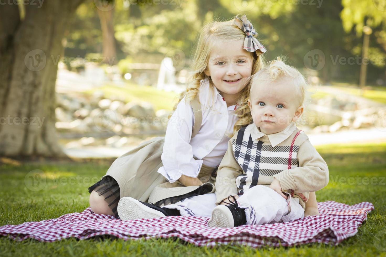 Sweet Little Girl with Her Baby Brother at the Park photo