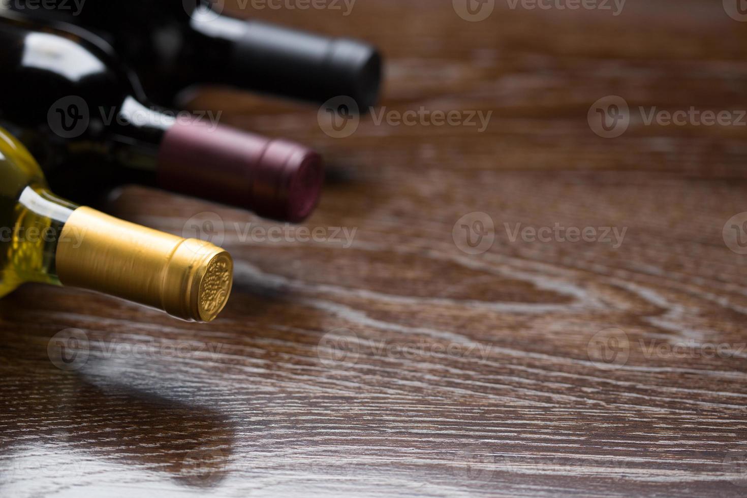 Various Wine Bottles on a Reflective Wood Surface Abstract. photo