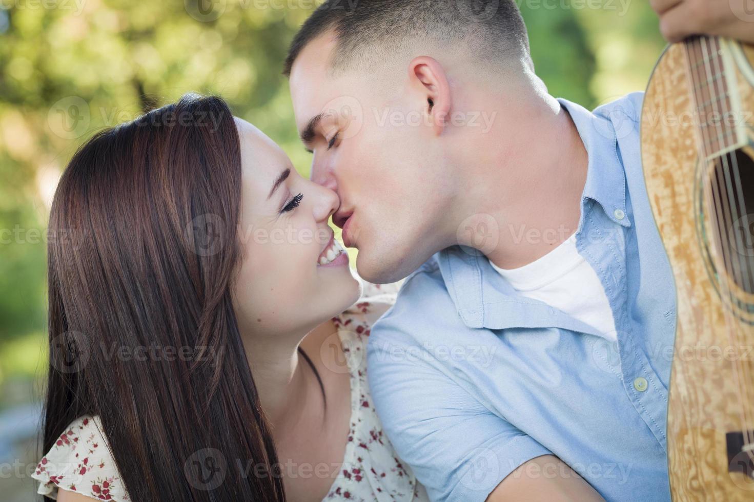 retrato de pareja de raza mixta con guitarra en el parque foto