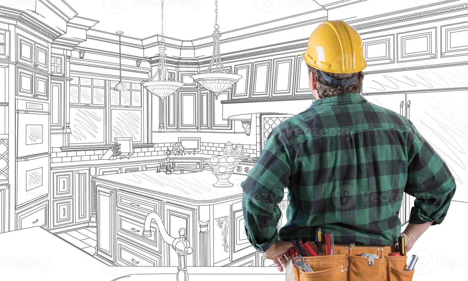 Male Contractor with Hard Hat and Tool Belt Looking At Custom Kitchen Drawing On White. photo