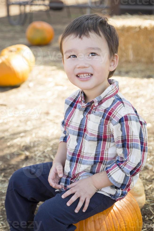 Mixed Race Young Boy Having Fun at the Pumpkin Patch photo