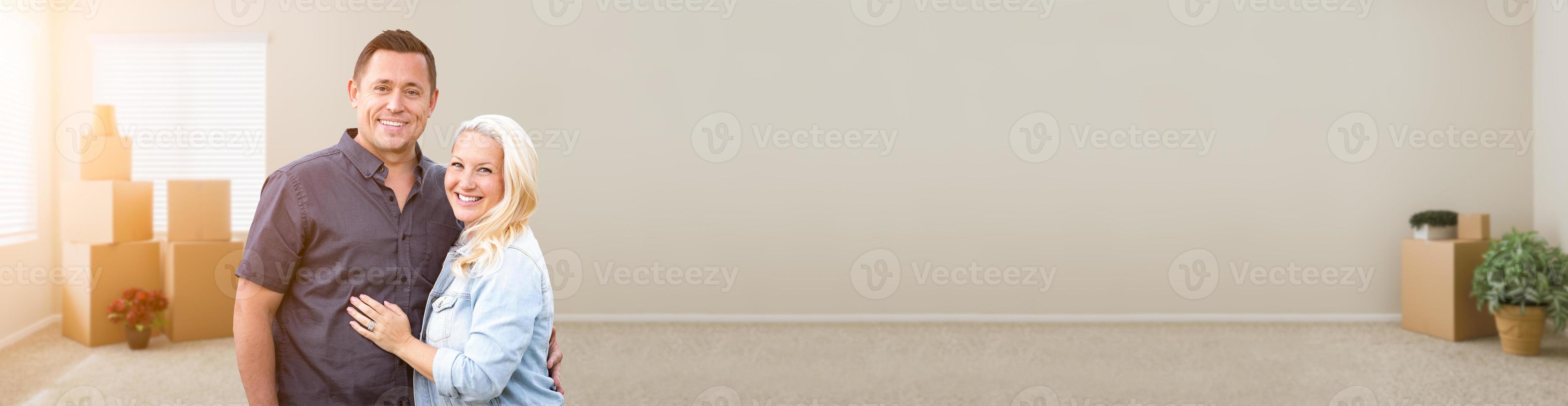 Happy Couple Inside Empty Room with Boxes Banner photo
