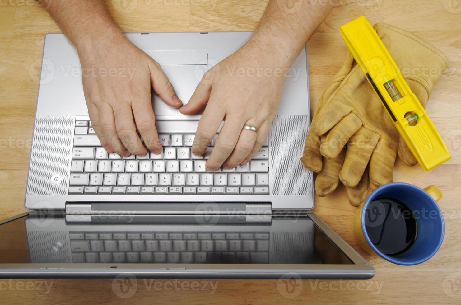 Contractor Reviews Project on Laptop photo