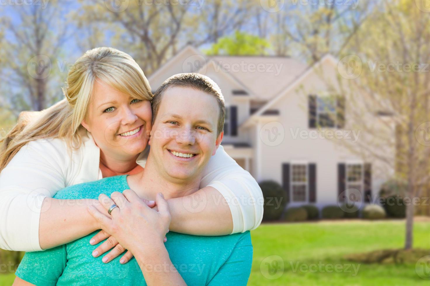 feliz pareja caucásica frente a la nueva casa foto