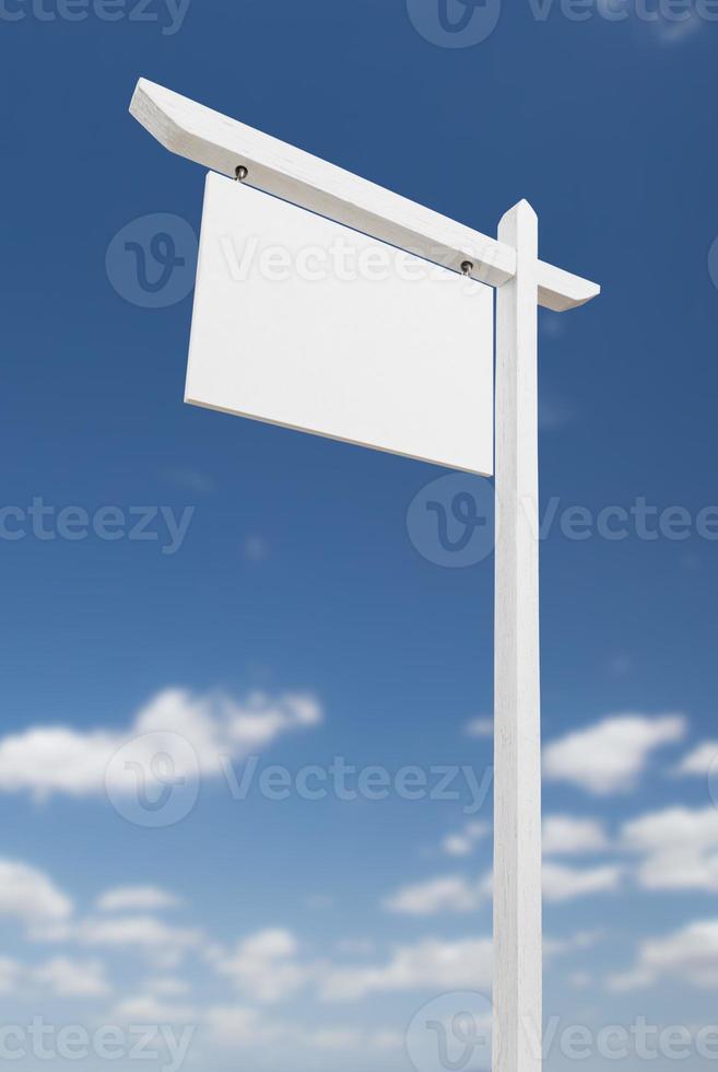 Blank Real Estate Sign Over A Blue Sky with Clouds. photo