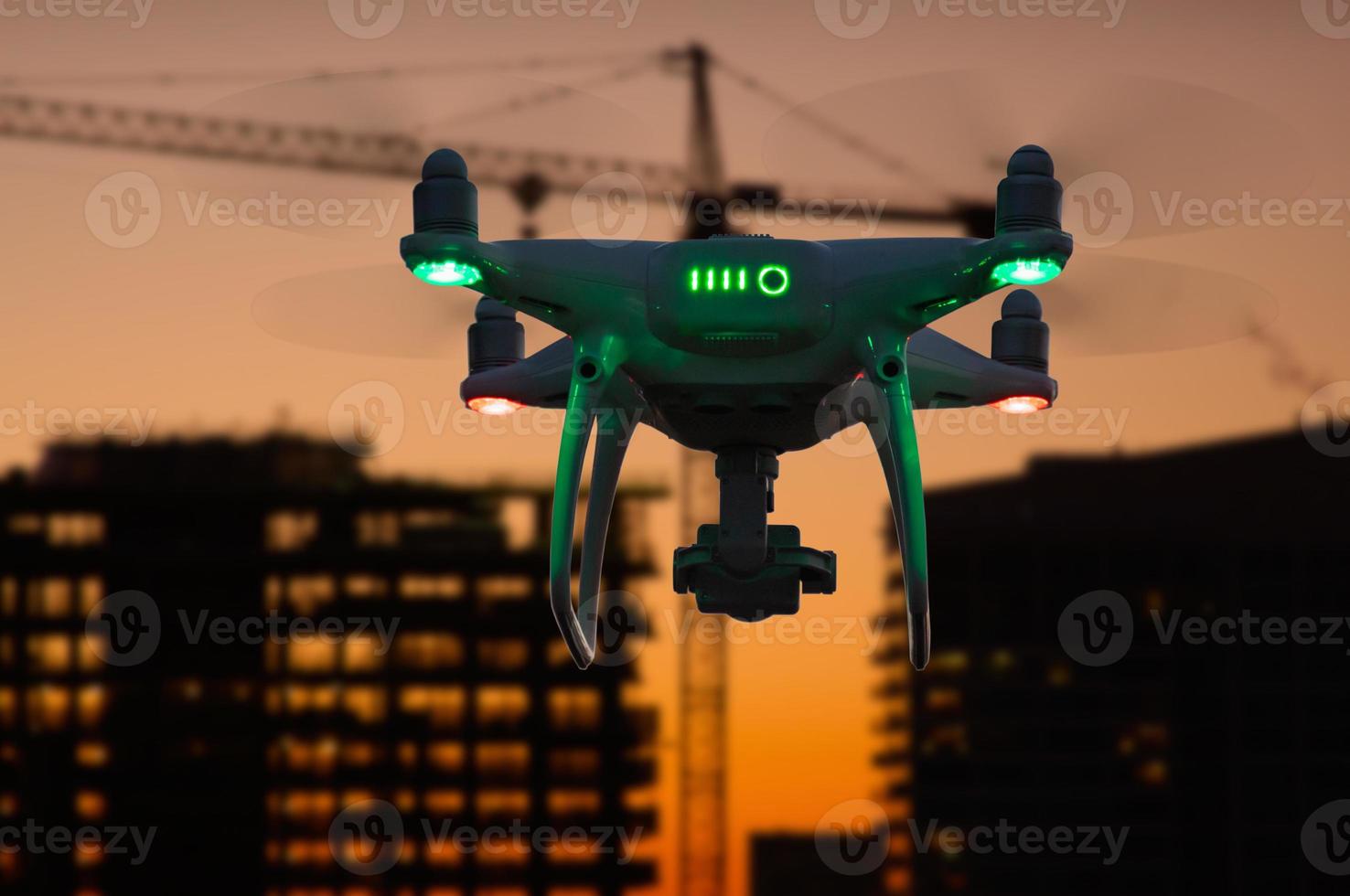 Silhouette of Unmanned Aircraft System Drone In The Air Over Buildings Under Construction photo
