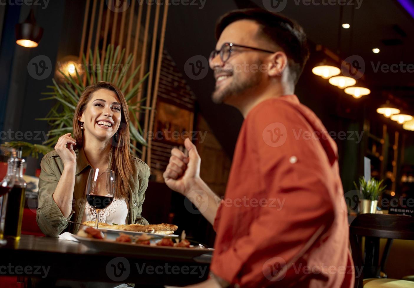 Young people having dinner in the restaurant photo