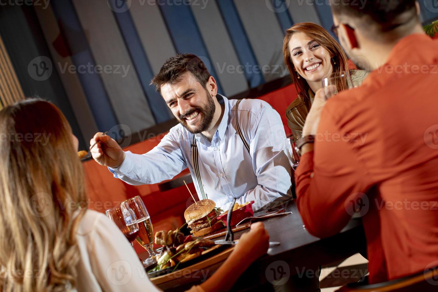 Young people having dinner in the restaurant photo