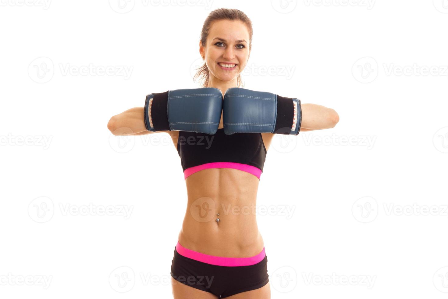 athletic young girl stands up straight and holding hands before breastfeeding in boxing gloves photo