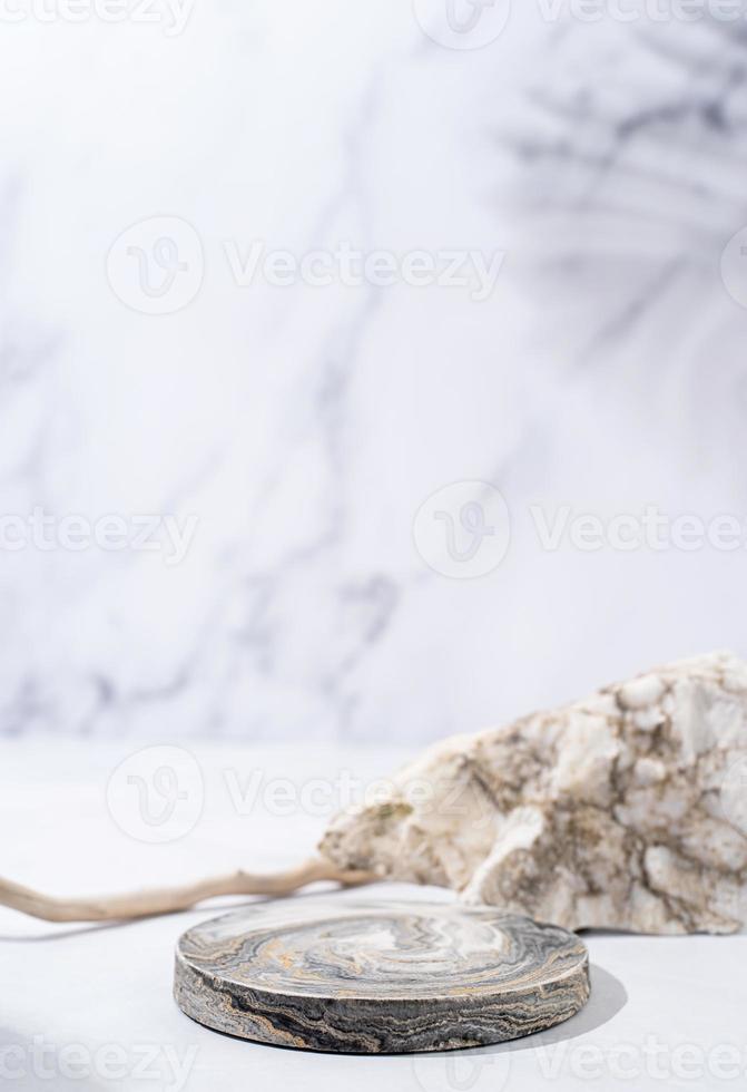 A minimalistic scene of a podium with wood and stones on white background, for natural cosmetics photo