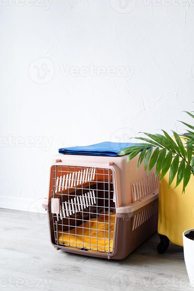 plastic pet carrier or pet cage with yellow travel case on the floor at home, pet corner plastic pet carrier or pet cage with yellow travel case on the floor at home, pet corner photo