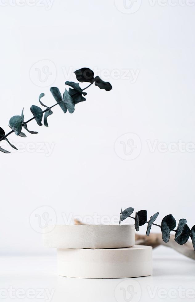 A minimalistic scene of a gypsum podium with stones on white background, for natural cosmetics photo