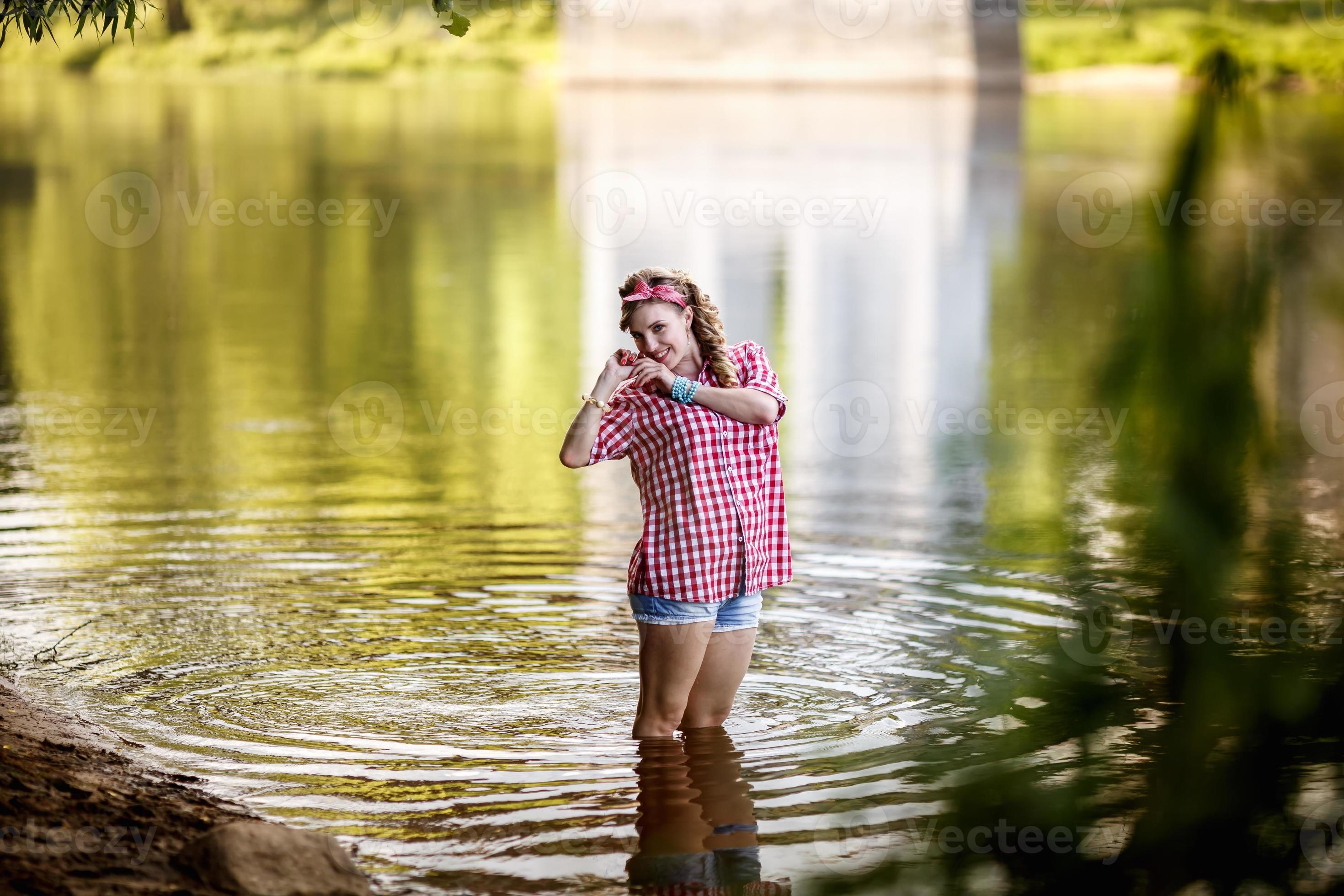 beautiful young girl in a plaid shirt and short denim shorts in pinup