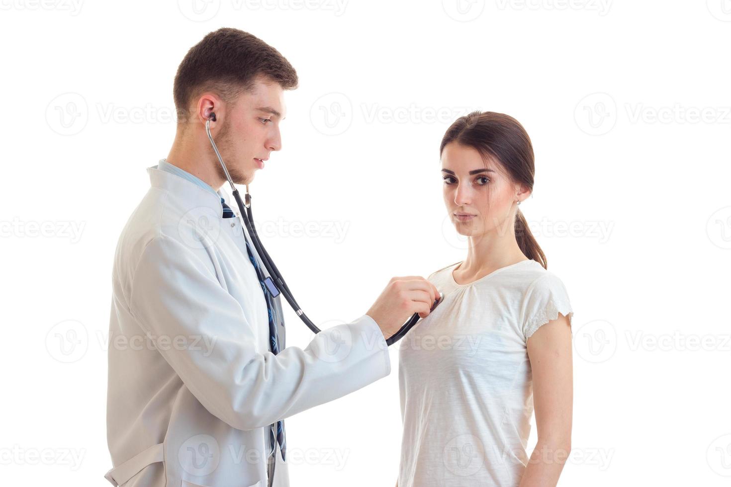 doctor in white robe at his patient's heart listens stethoscope close-up photo