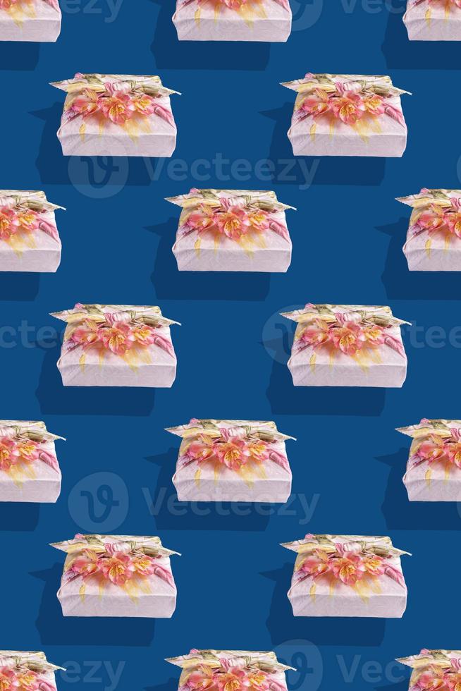 Seamless pattern of gift boxes trendy wrapped in cloth in Furoshiki technique with shadows on Classic Blue background. photo