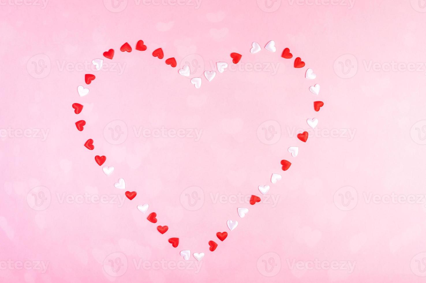 Valentines day festive background or greeting card. Small textile white and red hearts laid out in shape of heart. photo