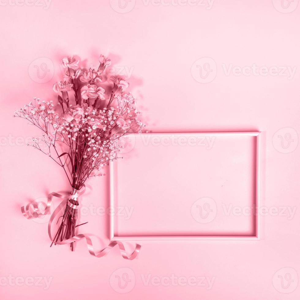 Empty frame, bouquet of gentle carnation and gypsophila flowers in trendy color 2023 Viva Magenta. photo
