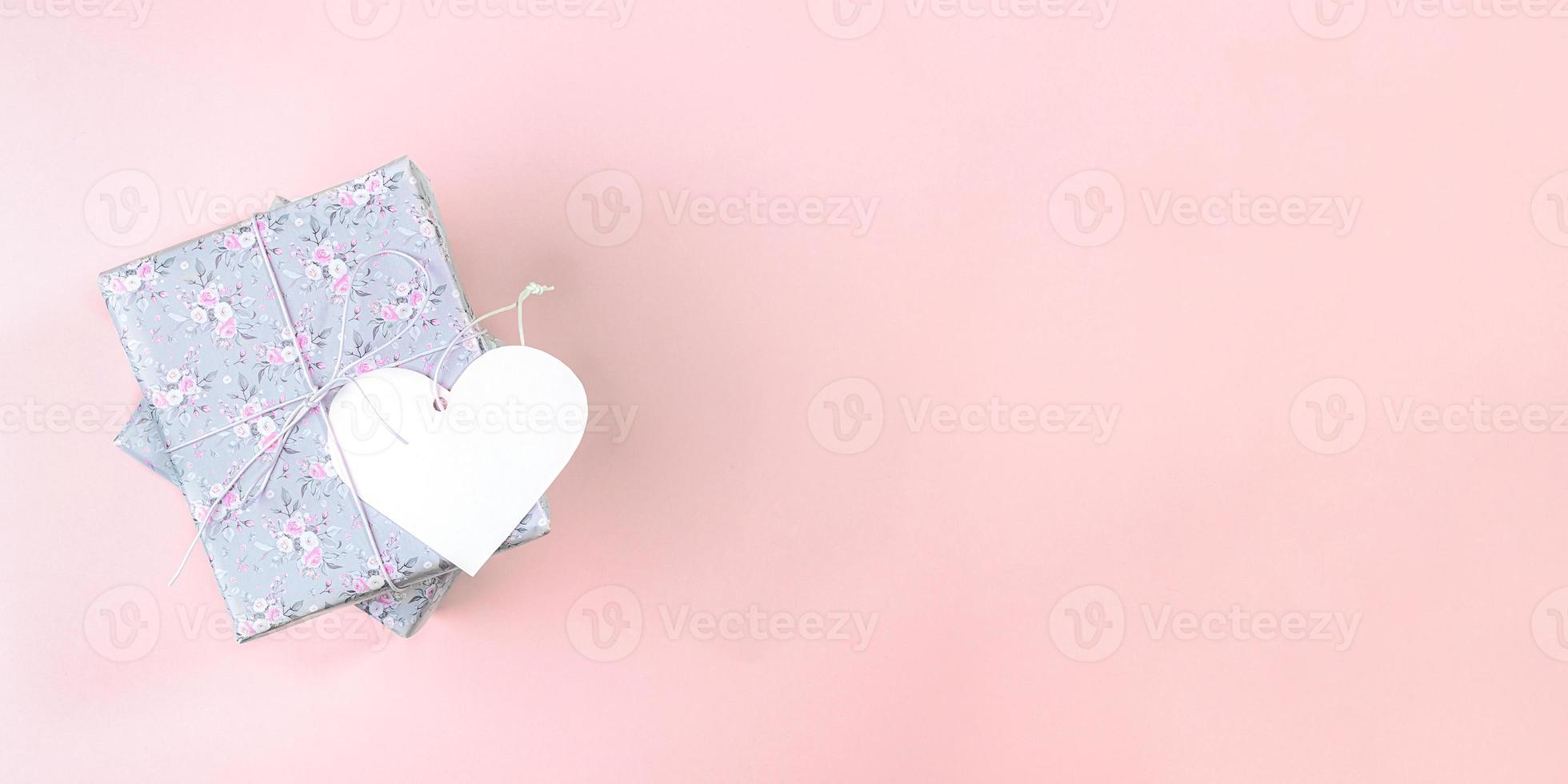 Valentine's day mockup banner. Gift boxes wrapped with grey paper with floral pattern and white paper heart  on pink. photo