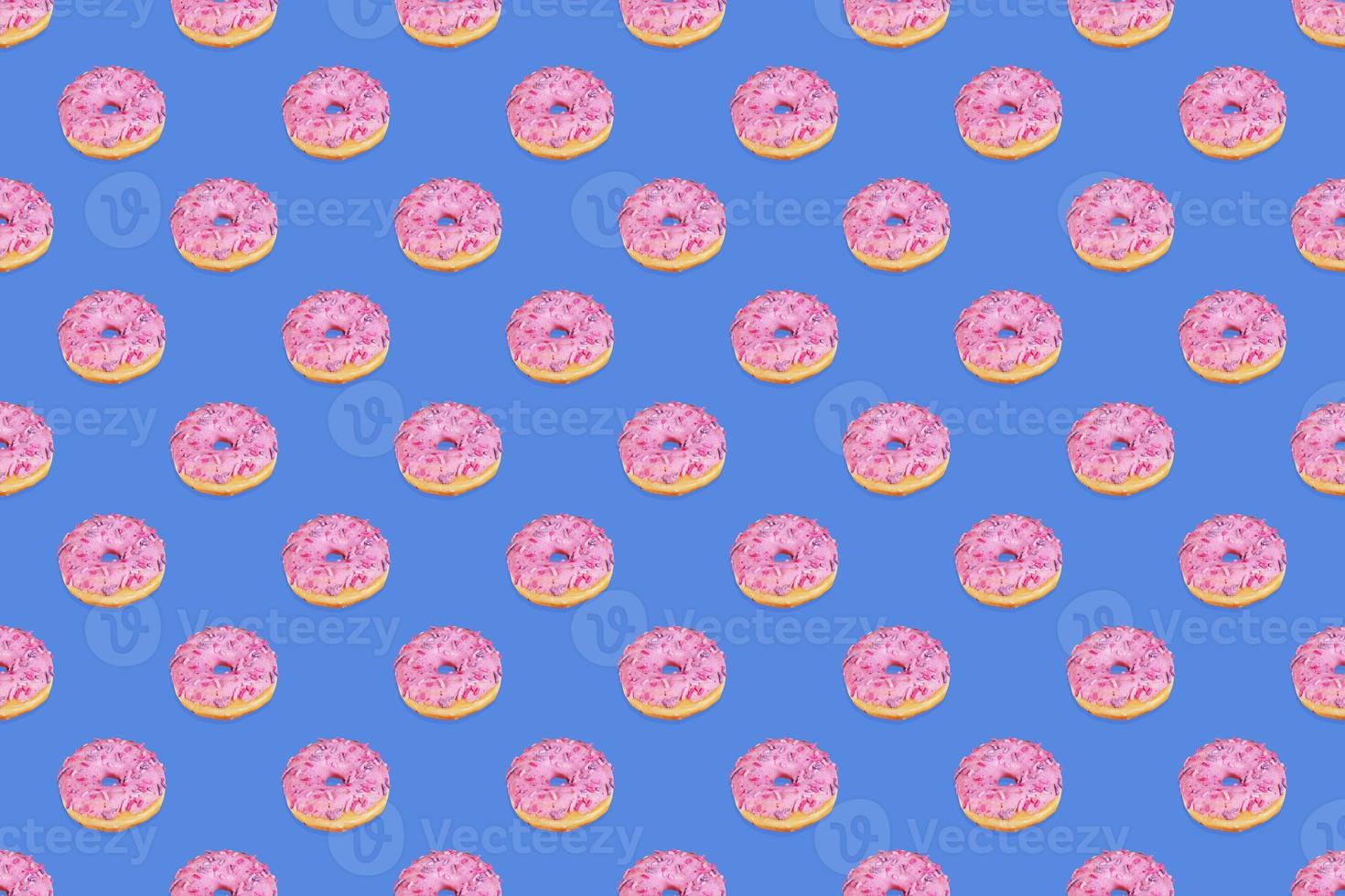 Fashionable seamless pattern of traditional doughnuts with lilac glaze on trendy classic blue background. Top view. photo