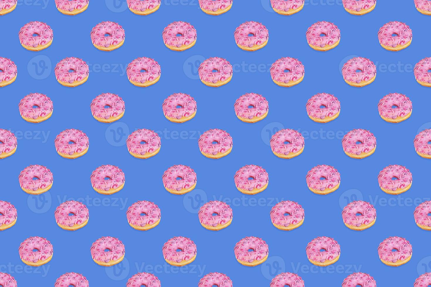 Fashionable seamless pattern of traditional doughnuts with lilac glaze on trendy classic blue background. Top view. photo