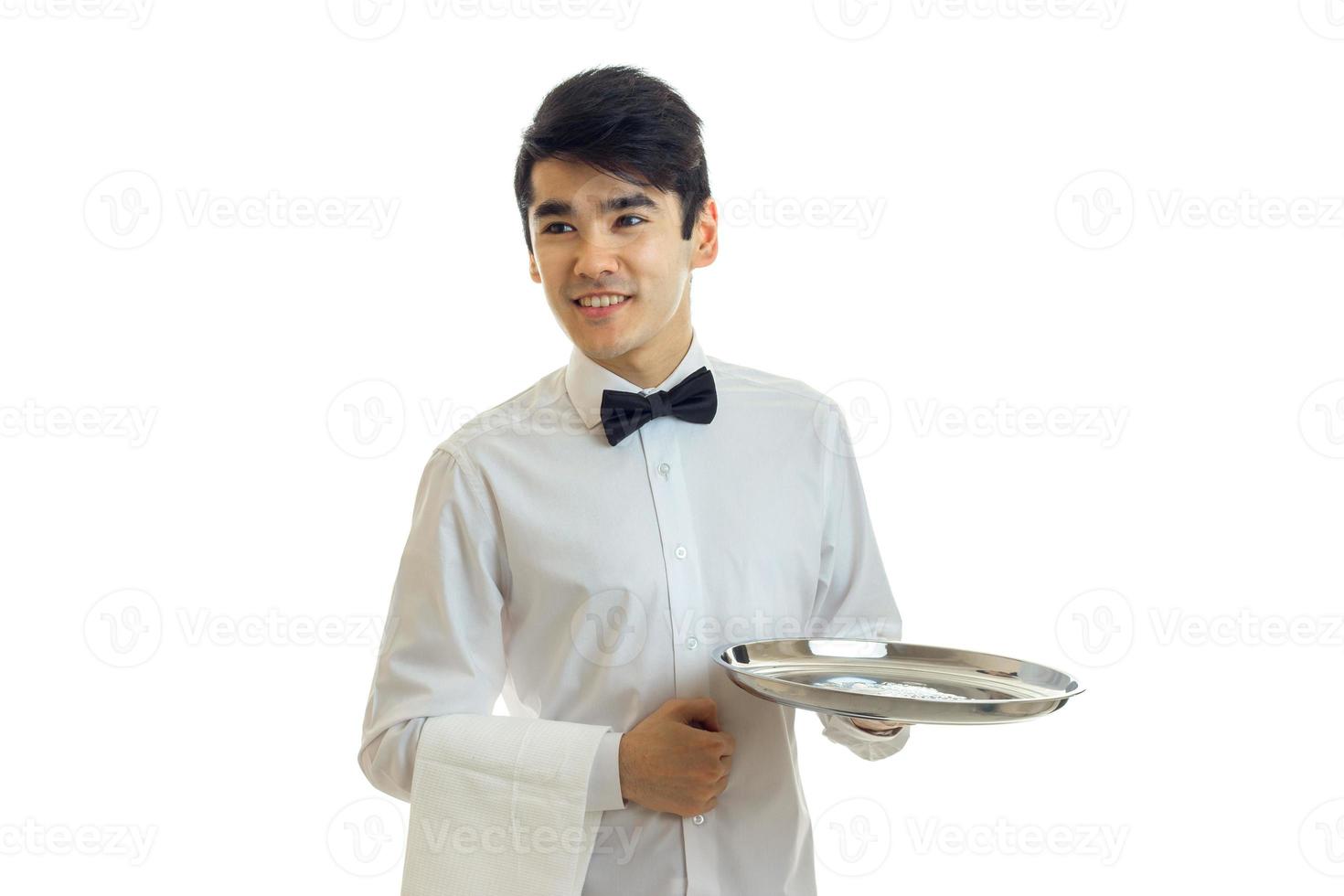 perky young waiter looks to the side and holding a blank tray for eating photo