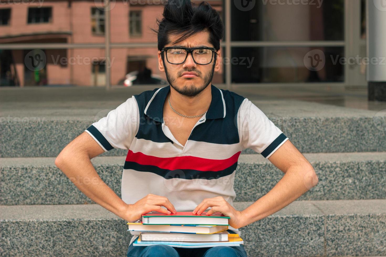 a young handsome student in glasses with books photo