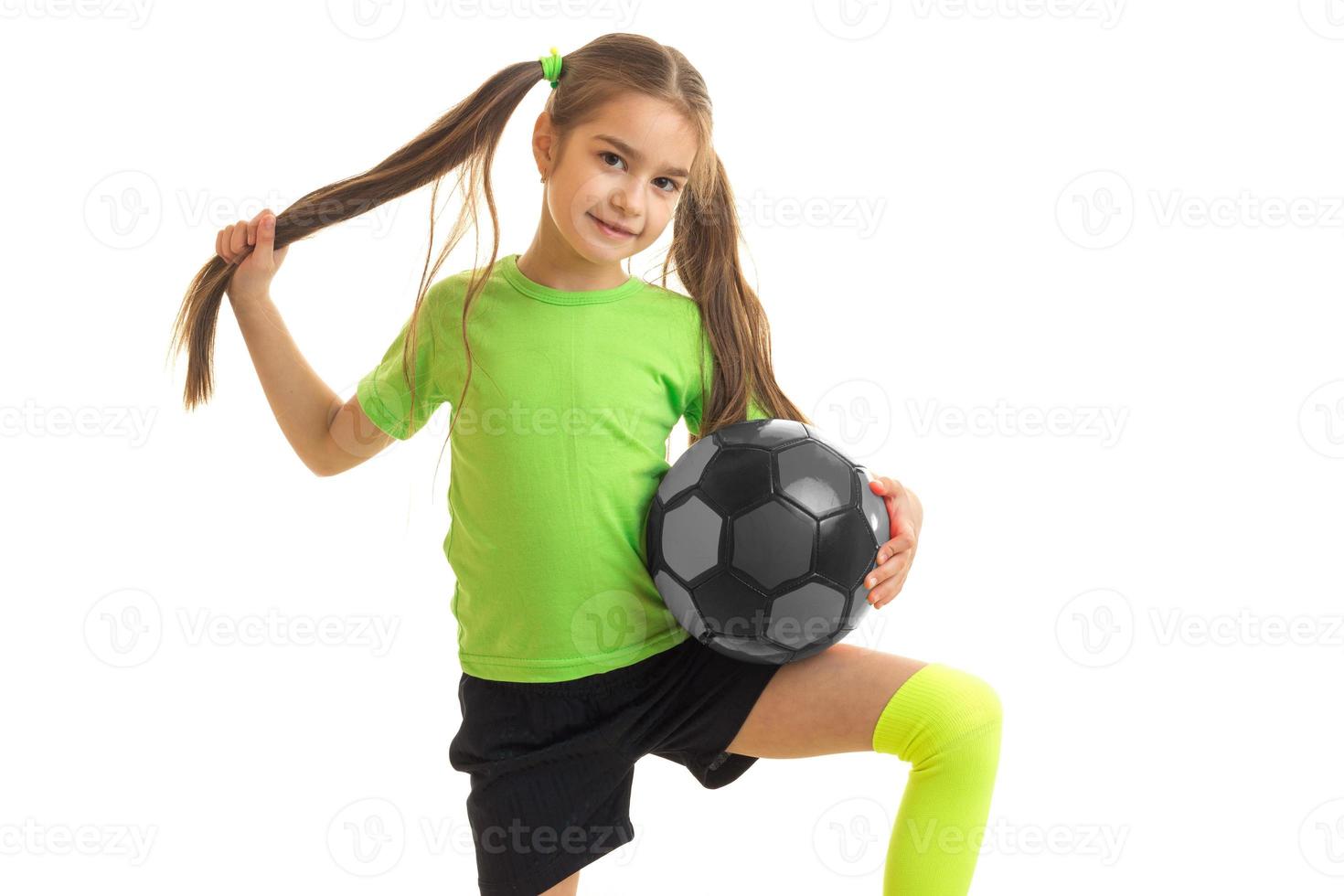 Cutie Little Girl juega al fútbol y mira a la cámara foto