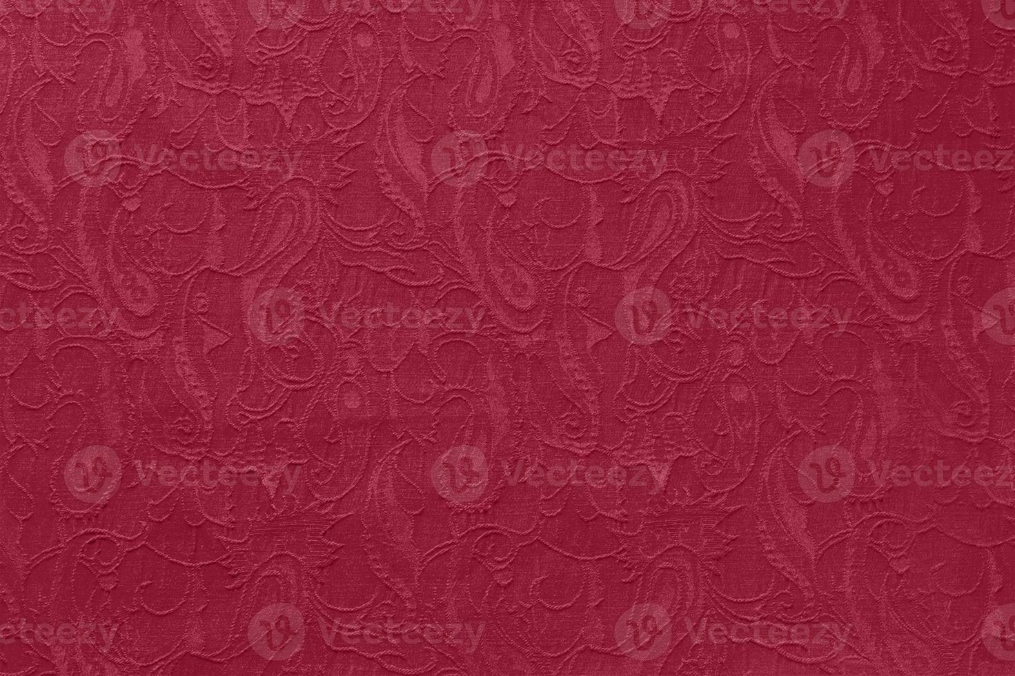 Beautiful ornate paisley ethnic fabric as background in trendy color 2023 Viva Magenta. photo