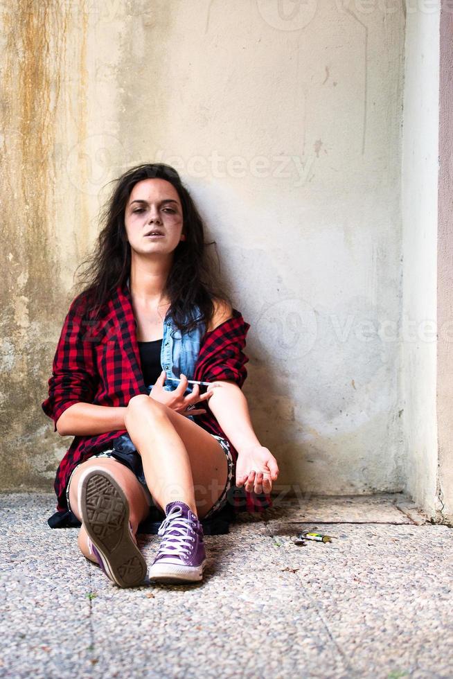 Drug-addicted girl who is crying with heroin syringe photo