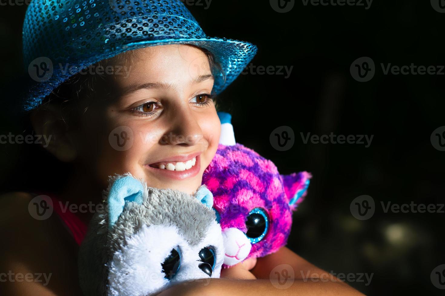 A little girl hugs her stuffed dolls photo