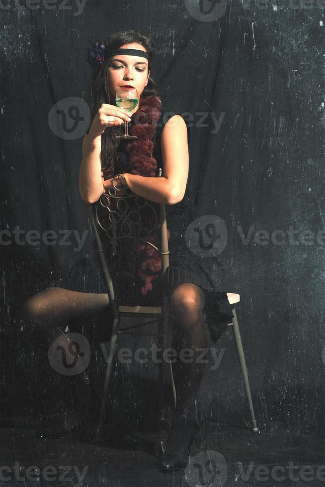 Vintage style photograph with created artifacts of a 30s style woman with alcohol photo